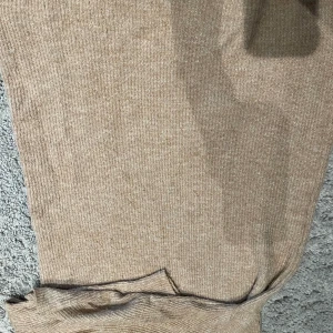 Lång stickad klänning - Den är varm och gosig. Storleken M, är i ljus brun färg. Har ett krage vid halsen. Lång till knäna. Använt den 3 gånger 