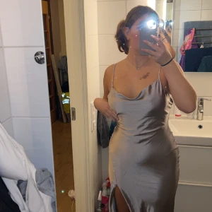 Balklänning - Säljer min balklänning från förra året. Den är silver grå. Köpt från Nelly. Köpt för 1000kr. Den ä storlek 38 och öppen o ryggen.