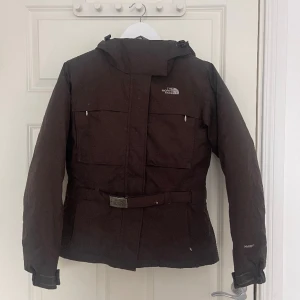 Jacka från Northface - Fin jacka från northface med skärp i stl xs. Har vissa fläckar men inget som inte går bort i tvätten. Annars bra skick. Färgen är mer chokladbrun i verkligheten än vad som visas på bilden. Pris kan diskuteras