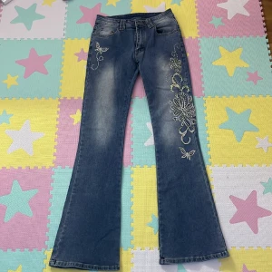 Blåa jeans med strass - Snygga jeans med fjälls mönster! Helt fläckfri och har ej använts! 106cm i längden och 79cm i midjan.  kontakta om du har frågor!