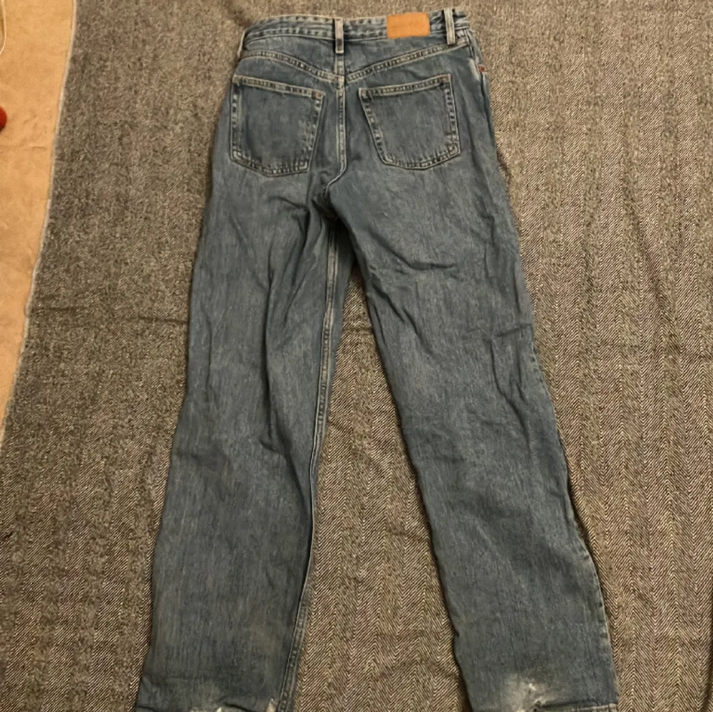 Ljusblåa jeans från Monki i storlek 26, ja är 160cm och ja tror att de skulle passa från typ 150-165cm. De är lite baggy och högmidjade. Använda och är lite slitna längst ner på båda benen.. Jeans & Byxor.