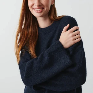 Stickad tröja från Ginatricot - Mjukt stickad tröja i mohairblandning med boxig passform. Tröjan är blå och har rund halsringning. Den har ribbstickning vid ärmslut och i nederkant.