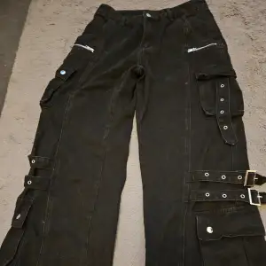 Svarta baggy jeans med massa fickor ,spännen och detaljer. Använda 2 ggr  Katt finns I hemmet