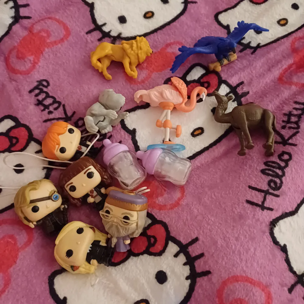 En samling av olika leksaksfigurer inklusive djur och karaktärer från populära serier. Samlingen innehåller en lejonfigur, en blå fågel, en rosa flamingo, en brun kamel, en grå elefant och flera karaktärer från harry potter . Övrigt.