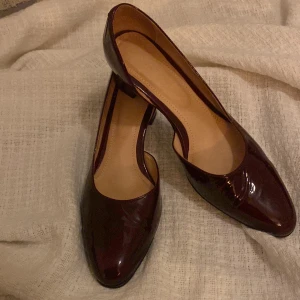 Vinröda klackskor - Jättefina vinröda skor i getskinnslack! Köpte på Vinted men var tyvärr för små. Tillverkade i Warszawa :) Står att det är storlek 41 men känns mer som 39/40