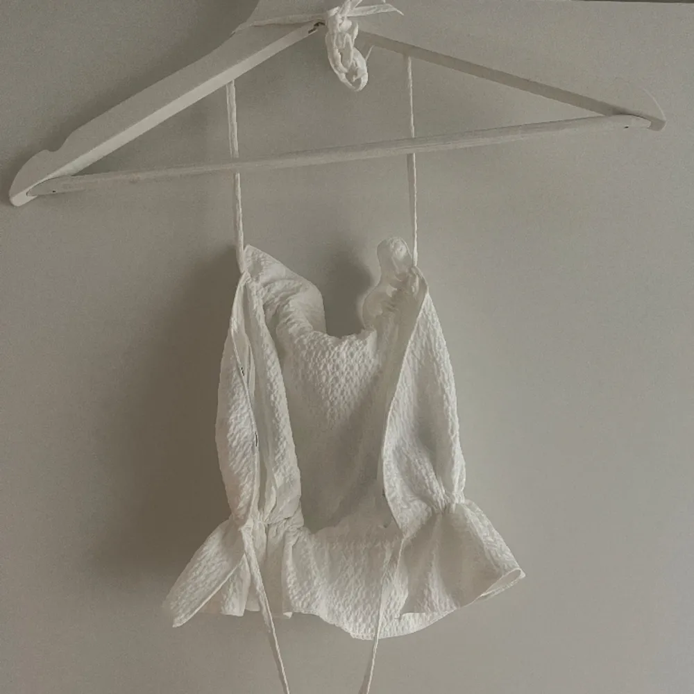 Somrig topp frĂ„n ginađ€ Ăppen rygg med justerbar knytning. YlĂ€osat.