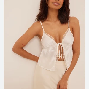 Spets topp - Säljer denna populära helt slutsålda toppen i satin med spets detaljer och knyte framtil från nakd, endast prövad!💖storlek 38 men mer som en 36🫶🏼