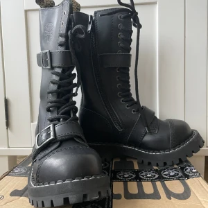 STEEL kängor, storlek 36 - Storlek: 36, något mot den tightare sidan. Läderskor Nypris: 179.96 euro, ~2017.85kr (enligt metal-shop.eu) Nästan helt oanvända, haft dem på mig en gång, ändast några små märken på hälarna som visas på sista bilden. Skickas med orginalförpackning!