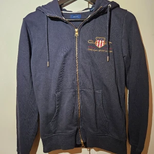 Gant Luvtröja med dragkejda  - Säljer nu min fina Luvtröja som jag inte använder. Tröjan har en väldigt bra passform. Den är i väldigt bra kvalité och använd få gånger utan några tecken på slitage. Fraktar inom 24h📦  Nypris ca 1799:- Skick 8,5/10