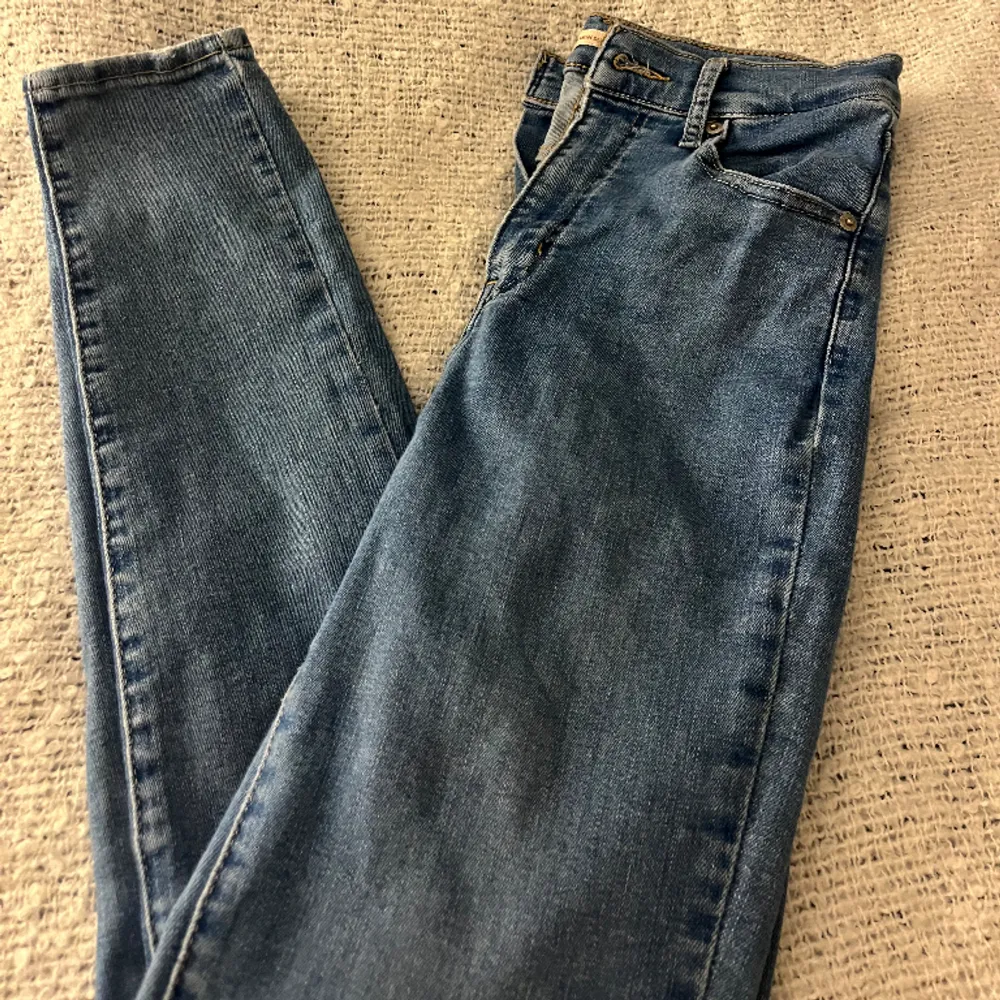Ett par blå Levis jeans i modell ”mile high super skinny”. Storlek 26 i midjan och runt 30/32 i längd. Ej använda på 2 år pågrund av att jag ej var helt nöjd med modellen så därav säljer jag dessa!. Jeans & Byxor.