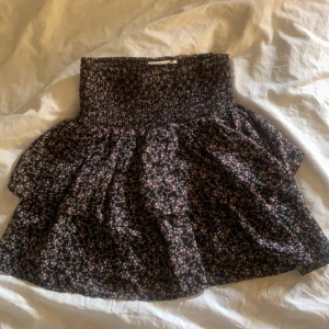 Kjol - Blommig kjol som funkar som både en topp och en kjol! Så fin, men kommer inte till användning o inga defekter alls! Från barnavdelningen men stretchig så funkar från XS till en M!