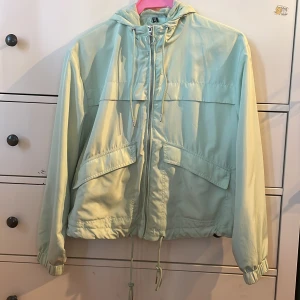 Ljusgrön jacka - Ljusgrön jacka i polyester, knappt använd, jättebra skick