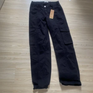Svarta jeans me fickor  - Svarta snygga byxor  Med mycket fickor :) storlek : 164 aldrig använd (pris kan diskuteras) men de lägsta jag kan är 145 eftersom att orginalpris är 399kr