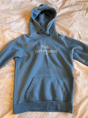 Peak Performance hoodie - Mycket fin blå hoodie från Peak Performance. Den är använd men är i fint skick. Något liten i storleken. Nypris 1200.