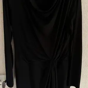 Svart klänning av Michael Kors, storlek L Snygg passform. Klänningen har en fläck längst ner, se bild, därav det låga priset. 