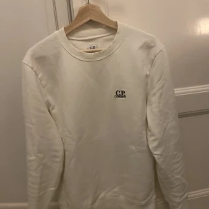 CP company tröja - Säljer nu min riktigt clean CP company tröja i en fräsch vit färg. Tröjan är mycket bra skick och som ni ser inga fläckar. Det är S och sitter även så. Tveka inte på att höra av er vid funderingar.