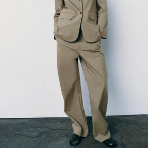 Zara kostymbyxor - Straight-leg byxor i ljus khaki. Använd en gång för ett fotoprojekt så i princip i nyskick!  Storlek S