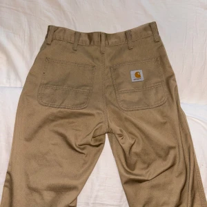 Carhartt byxor - Beige/bruna carhartt byxor i storlek W28, L32. Säljer för att dom inte har kommit i så stor användning. Har endast användt dom 2 gånger och är som nyskick