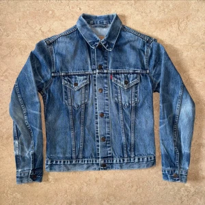 Dam Vintage Levis Trucker Jeansjacka - Vintage Levis jeansjacka med artikelnummer: 70590 Storlek: L (Dam) men sitter mindre. Hål i armana, syns på bilden. 