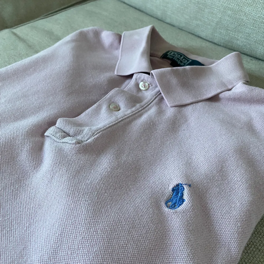 En rosa Ralph Lauren piké med blått märke. Den är i ganska bra skick. Den är i storlek M. Nypris är 1200kr men mitt pris är 299kr. Skriv för frågor och funderingar!. T-shirts.