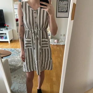 Klänning - Oanvänd klänning, justerbar knytning i midjan. Hittar ej någon storlek på dem men skulle tro att det är S