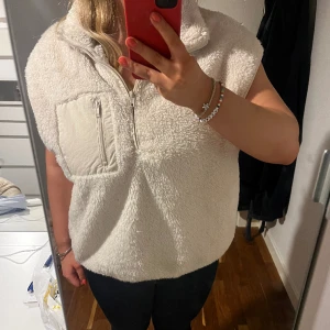 Fleece väst - Crémefärgad fluffig väst med en kvart dragkedja.