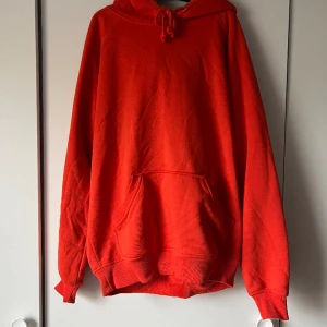 Orange hoodie - Sparsamt använd, från Bikbok. Storlek XS/S Bild 2 är jämförelse med en röd tröja för att se färgen ordentligt, den är mörkare orange än gulbrand.  Köparen står för frakt
