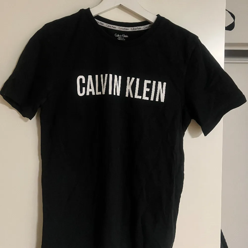 En stilren svart T-shirt från Calvin Klein  Använd ett fåtal gånger, storlek 164/176cm men skulle säga att den passar allt från XS-M . T-shirts.