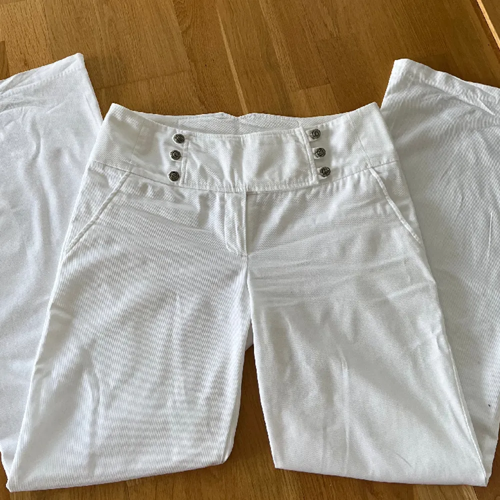 Låg/midwaist vita byxor med snygg knäppning där fram! För långa för mig som är 165 (andra bilden) midja: 41 cm innerbenslängd: 81cm Ytterbenslängd: 105 cm. Jeans & Byxor.