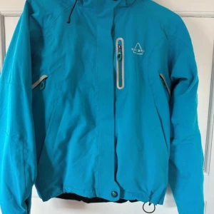 Blå skidjacka - Jättefin skidjacka som tyvärr inte passar löngre, bilderna är lånade. Den har snölås, bra reflexdetaljer och det finns dragkedjor vid armarna som går att öppna om man blir varm. Storlek 36. Pris kan diskuteras 