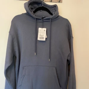 Hoodie - Säljer denna trendiga blåa hoodie i storlek XS. Den e ganska overzised. Aldrig använt och prislappen är kvar!