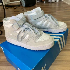 Adidas forum mid vita/grå sneakers - Säljer mina assnygga Adidas sneakers som jag aldrig använt typ! Storlek 38 :) 