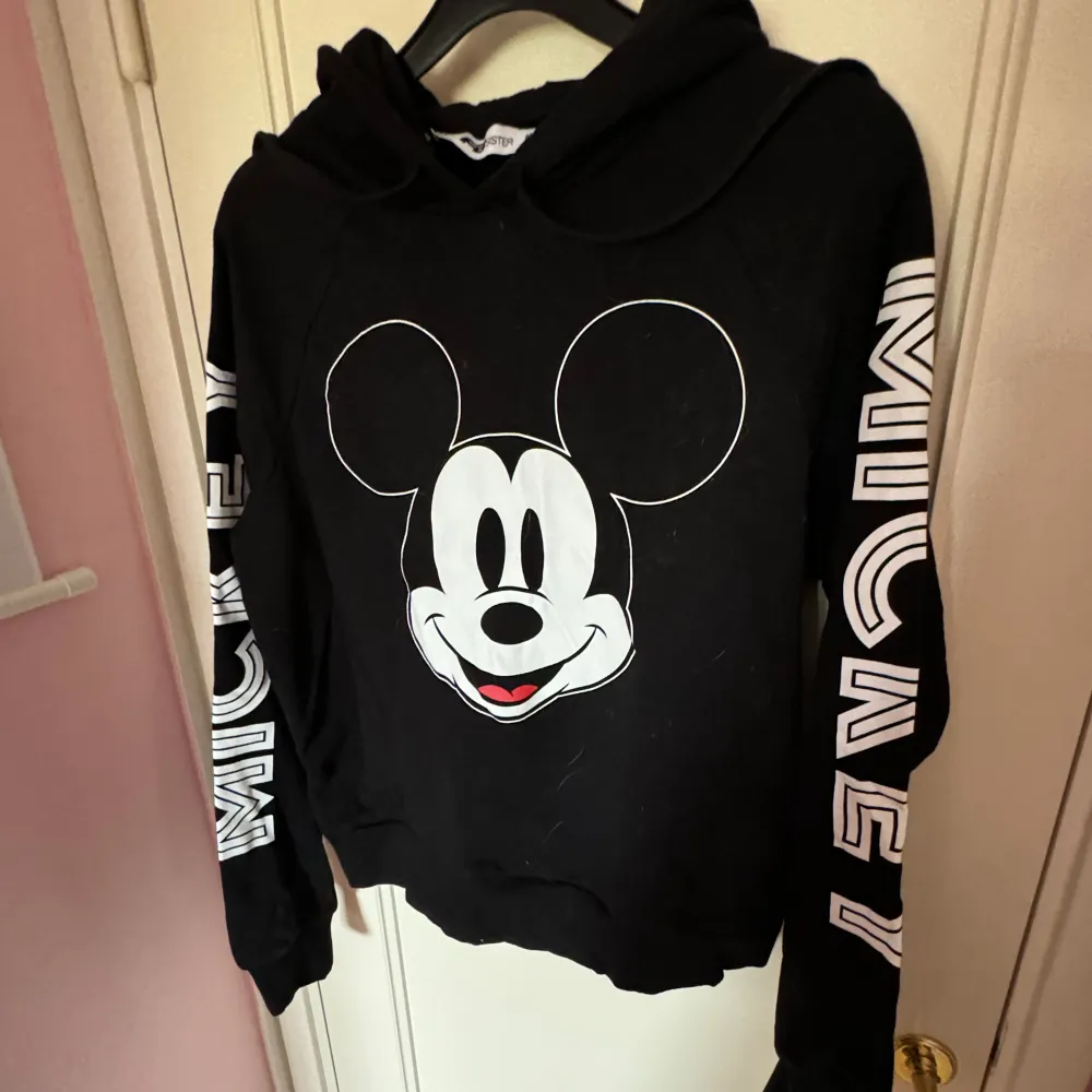 En mjuk svart hoodie med Mickey mouse tryck. Storlek M kan öven passa S.   Katter finns i hemmet. Hoodies.