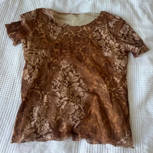 Printad Mesh topp  - Brun/orange printad Mesh T-shirt som ej är see through.  Passar XS-M . Knappt använd 