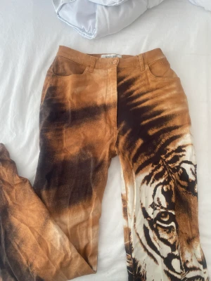 Byxor lejon  - Byxor med lejon print storlek 38, köpta på humana. Flare med mid/highwaist. Använda 2 gånger 