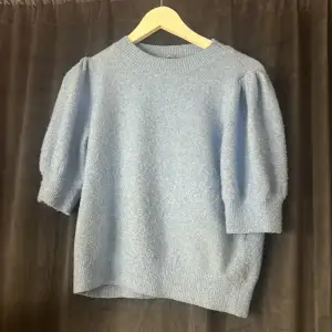 Superfin blå stickad t-shirt med puffärmar. Den har endast några noppror men får att ta bort super lätt. Andvänd endast 3 ggr. Köpt för 399kr men säljer nu för 300kr, priset kan diskuteras. 💕💕💕