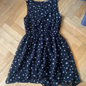 Säljer en oanvänd svart klänning med stjärnor på