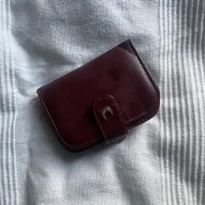 söt, vinröd plånbok ! köpt secondhand. den kom aldrig till användning, så säljer den. den är lite sliten, men ändå fin. 