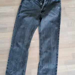 Grå-svarta jeans från Jack & Jones, modell Relaxed/Chris. Storlek 33/32. Fint skick men det fins en nötning på ena fickan (se bild).