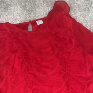Röd blus med volang  - Bra skick, storlek 158 cm, köpt på Lindex , köpt för 250 säljer för 120 kr+ frakt . 🚚 säljer då den är för liten. Passar fint till allt💓 skriv vid frågor! Svarar så snabbt jag kan 