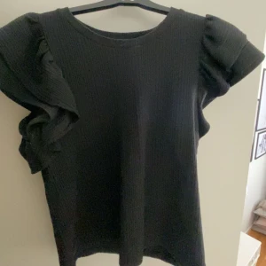 Svart topp med volang ärmar - Säljer en jättefin svart topp med volang ärmar. Den är från zara i strl M men är mer som strl S. Använd men i jättefint skick. 