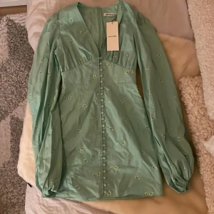 Adoore klänning  - En helt ny adoore klänning (aldrig använd endast testad).  Säljer då den var för liten för mig. Armarna är dock ganska långa.  Storlek: 34 passar för 32 & 34 endast långa armar. Färg: grön med blommor