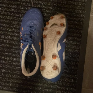 Blåa fotbollsskor i storlek 39 - Begagnande fotbollsskor, smutsiga dobbar som går att tvätta, nypris ca 800kr men budet startar på 130kr.  Tel:0760706942