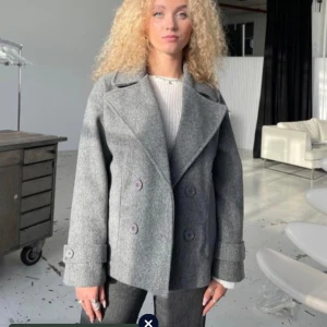 Grå kappa  - Jag säljer min gråa kappa från design by si då den inte kommer till användning längre den är i storlek xs/s säljer den för 300kr.