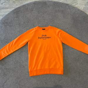 En superfin orange peak performance tröja som är helt oanvänd. Givetvis äkta. Köpt för 600 kr. Tveka inte på att höra av dig vid frågor!