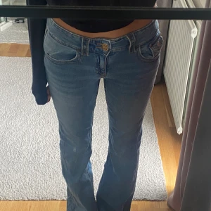 Lågmidjade bootcut jeans - Lågmidjade bootcut jeans ifrån ginatricot med snygga detaljer!! Är storlek 164 ifrån gina young men passar även 34. Man kan spänna in i midjan. Knappt använda då de var försmå