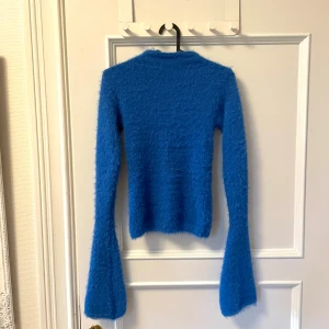 Blå tröja från weekday - Blå ”fluffig” tröja från weekday med utsvängda ärmar och lite högre halsringning. 