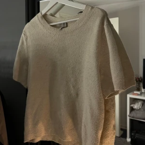 Stickad t-shirt - Jag säljer en beige stickad t-shirt från H&M i ett relativt fint sick. Säljer för att jag inte får användning för den💕 den är lite smått nopprig och har tyvärr en fläck därav priset. Vid köp ska jag göra allt för att försöka få bort den🥰(se bilderna)