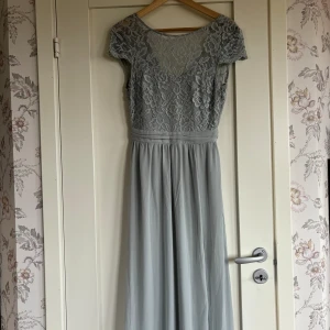 Balklänning  - Mycket fin balklänning helt som ny endast använd en gång. Storlek 34 men passar även 36. Klänningen är blå/grön 