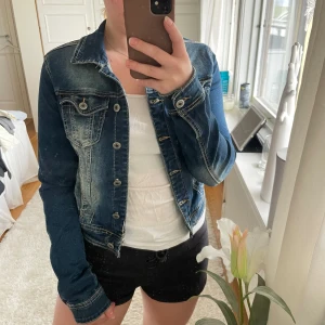 Jeansjacka - Inköpt på Chelsea. Mycket fint skick! Lite längre i armarna och lite kortare i modellen. Knapparna låter lite när man rör sig. Väldigt strechig. 